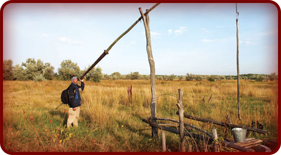 The fulcrum of a shadoof sits between the effort and the load, making it a first-class lever. This man is using a shadoof to lift water from a deep well.